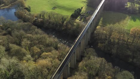 Old-Welsh-Pontcysyllte-Aqueduct-waterway-aerial-view-rural-Autumn-woodlands-valley-tilt-down-to-river-bank