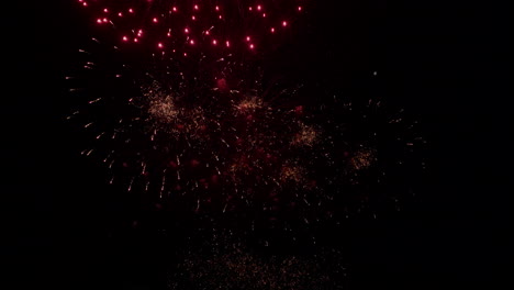 Explosions-of-light-and-color-from-fireworks-display-bursting-in-black-night-sky