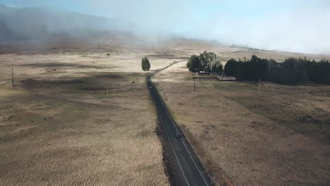 Aerial-view-tilting-up-to-reveal-car-driving-through-Hawaii-Island-countryside