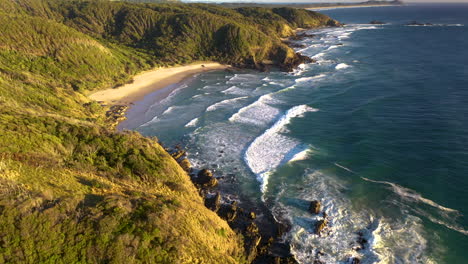 Rising-drone-shot-of-rocky-coasting-and-crashing-waves-at-Broken-Head-beach-near-Byron-Bay