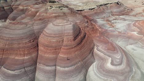 Aerial-View,-Person-Walking-Down-on-Layered-Sandstone-Hill-in-Utah-Desert,-Mars-Look-Alike-Landscape,-Drone-Shot