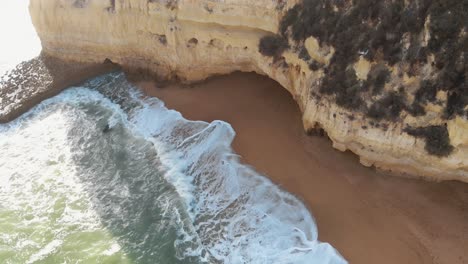 Golden-beach-and-rock-outcroppings-in-Carvoeiro,-Algarve,-Portugal---Descent-Aerial-shot