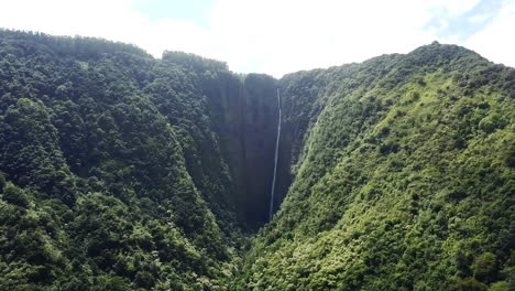 Aerial-of-high-waterfall-and-lush-green-hills-at-Waipio-Valley,-Hawaii