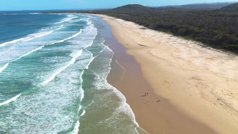 Cinematic-revealing-drone-shot-of-sandy-beach-and-rock-outcropping-at-Cabarita-Beach-Australia