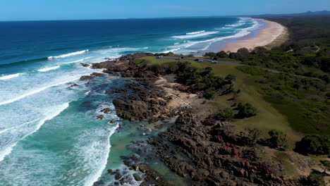 Drone-shot-stating-on-coastal-rock-outcropping-going-to-wide-shot-at-Cabarita-Beach-Australia