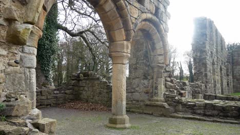 Ancient-Basingwerk-abbey-abandoned-historical-landmark-building-arched-stone-walls-dolly-left