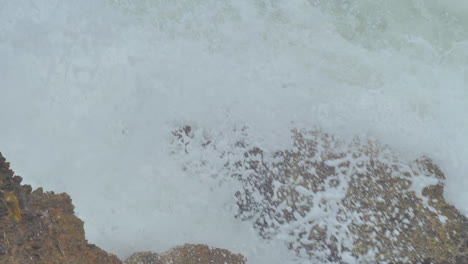 Slow-motion-cinematic-shot-of-a-wave-crashing-on-a-rock