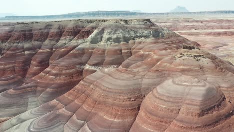 Aerial-View-of-Scenic-Layered-Sandstone-Hills-and-Lonely-Man-in-Dry-Utah-Desert-Landscape-on-Hot-Sunny-Day,-Drone-Shot