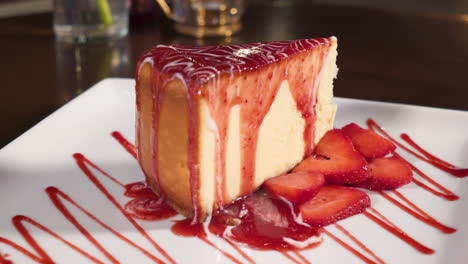 Decadent-strawberry-cheesecake,-fresh-strawberries-and-drizzle-decorate-slice,-slider-slow-motion-4K