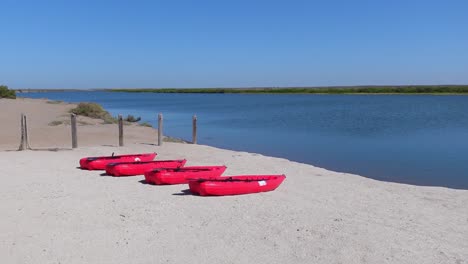 Einspielung,-Malerischer-Blick-Auf-Die-Strandküste-In-Isla-Holbox,-Mexiko,-Rotes-Pumpboot-Auf-Dem-Sand-Im-Hintergrund