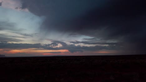 Slow-panning-shot-of-a-desert-sunset-with-thunderstorm-approaching