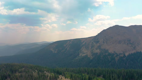 Luftaufnahmen-Der-Niederländischen-Colorado-Berge,-Die-Mit-Dichten-Kiefernwäldern-Bedeckt-Sind,-Mit-Wolken,-Die-Im-Sommer-In-Den-Rocky-Mountains-Schatten-Werfen
