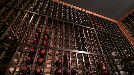 Lavish-floor-to-ceiling-wine-rack-holds-stacks-of-bottles,-slider-HD