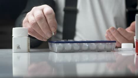 Old-man-dividing-his-weekly-pills-by-the-Medicine-pill-case---Static-close-up-shot