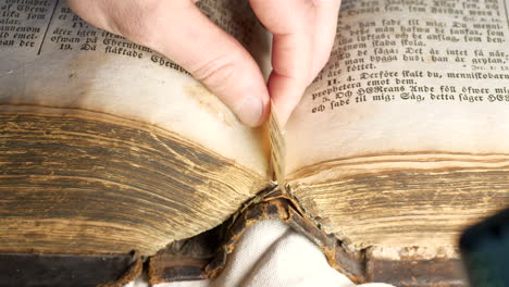 Caucasian-hand-removes-bookmark-from-historic-bible,-slow-motion