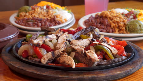 Sizzling-beef-and-chicken-fajita-combo-platter-with-sides,-close-up-slider-slow-motion-4K