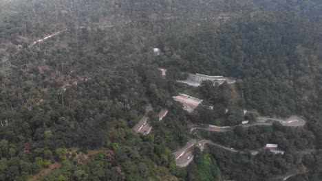 Yercaud-highway-hairpin-bend-covered-with-thick-lush-of-trees-and-vehicles-are-passing-in-the-highway
