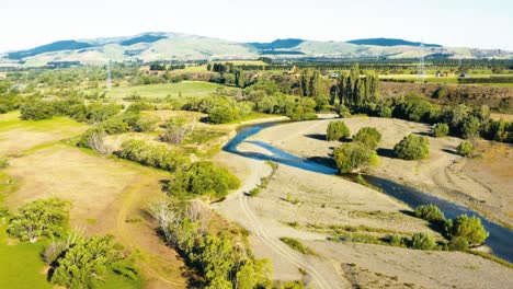 Aeria-Blick-Um-Einen-Kleinen-Bach-Auf-Ein-Grünes-Tal-Der-Neuseeländischen-Landschaft