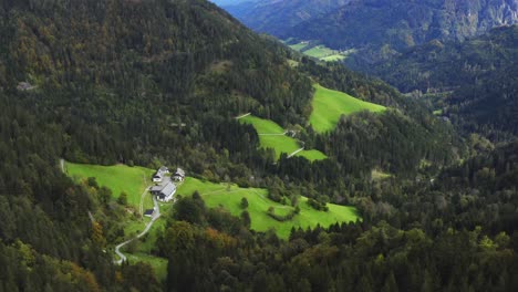 Vista-De-Drones-De-Una-Casa-En-El-Valle-De-La-Montaña-Rodeada-De-Bosque