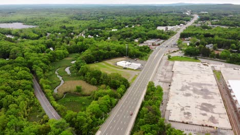 Aerial-daytime-drone-view-of-buildings-and-four-lane-roadway-above-Route-1-in-Foxboro,-MA,-USA