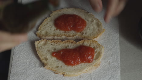 Caucasian-hands-prepare-pizza-for-snack,-on-bread's-slices,-with-tomato-sauce-and-mozzarella-cheese