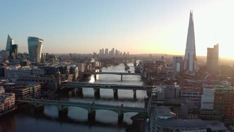 Establishing-Aerial-drone-dolly-back-shot-of-thames-river-London-city-centre-sunrise