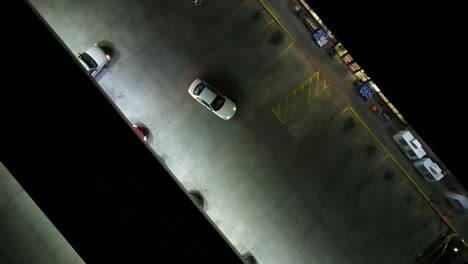 Aerial-shot-from-drone-of-people-coming-and-going-at-a-gas-station-at-night