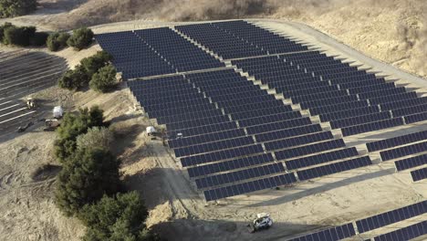 Aerial-descending,-solar-panel-farm-on-top-of-mountain-top,-green-technology