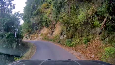 View-through-dash-camera-showing-SUV-driving-through-narrow,-dangerous-and-curved-mountainous-roads
