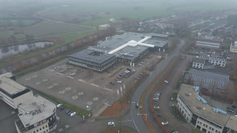 Aerial-of-office-building-on-busy-industrial-terrain-in-foggy-weather