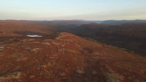 Upgoing-drone-footage-of-mountain-plateau,-lakes-and-valley-at-sunset-in-Southern-Norway