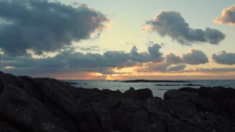 Motion-Timelapse-Of-Clouds-Moving-Above-Rocky-Ocean-On-A-Sunset---wide-shot