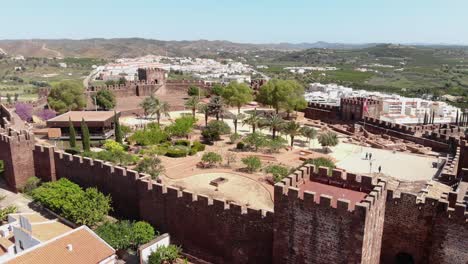 4k-aerial-drone-footage-circling-the-walls-of-the-Castle-of-Silves-and-the-beyond-cityscape-of-the-historical-town-of-Silves-along-the-banks-of-the-Arade-River-in-Portugal