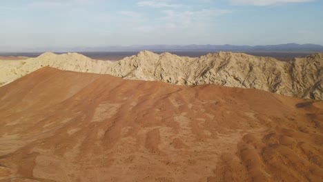 Aerial-view-of-UAE's-Al-Faya-mountain-range-landscape,-Sharjah's-Kalba-mountains-in-the-background,-Al-Faya-desert,-United-Arab-Emirates