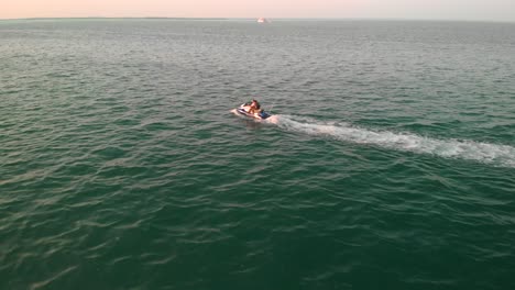 Drone-following-a-jet-ski-cruising-on-calm-sea,-Persian-Gulf-Abu-Dhabi