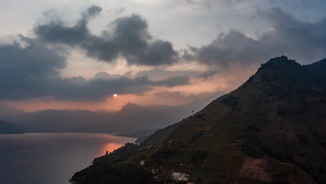 Drone-aerial-hyperlapse-with-a-beautiful-sunset-behind-the-mountains-in-Lake-Atitlan,-Guatemala