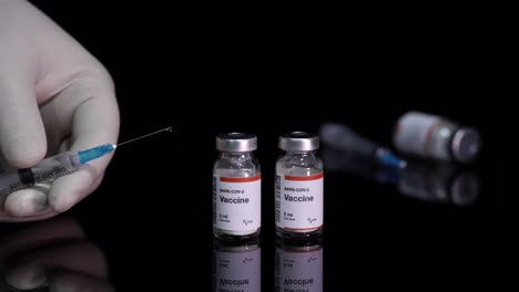 Covid-19-Impfstoffflaschen-Und-Hand-Halten-Eine-Gefüllte-Spritze-Zur-Behandlung-Der-Coronavirus-Pandemie