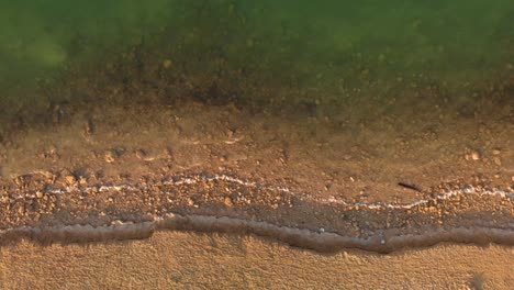 Sanfte-Wellen-Umrunden-Wüstenstrand,-Drohnenansicht-Von-Oben-Nach-Unten,-Abu-Dhabi,-Vae