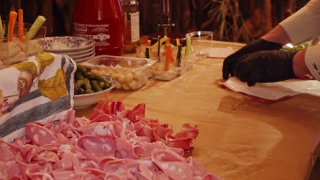 Chef-decorates-table-with-Parma-ham-meat-servings-at-night