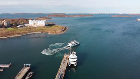 Daytime-drone-view-of-a-Ferry-pulling-away-from-dock-in-a-suburban-waterfront-community