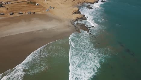 Aerial-View-Of-Surfers-Floating-On-Ocean-Surface-Near-The-Shore-In-Lobitos,-Peru-During-Summer