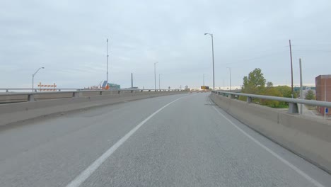 POV-driving-on-narrow-overpass-bridge-with-construction-barrels-on-Interstate-I74-near-the-Mississippi-River-in-Moline-Illinois