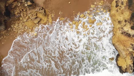 Luftaufnahme-Von-Meereswellen-Brechen-An-Einem-Felsigen-Sandstrand