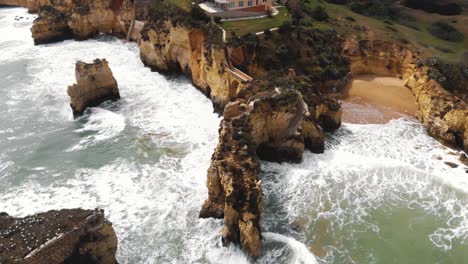 4K-Luftdrohnenaufnahmen-Der-Felsigen-Kalksteinklippen-Ponta-Da-Piedade,-Die-Sich-Aus-Dem-Transparenten-Ozeanwasser-In-Der-Nähe-Der-Küstenstadt-Lagos,-Portugal,-Erheben