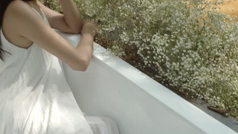 In-a-dreamy-picturesque-garden-tub,-a-beautiful-Asian-bride-poses-by-the-pond