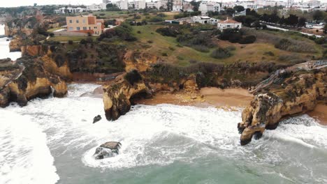 Waves-crashing-on-rocks-and-cliffs-along-Lagos-coastline,-Algarve,-Portugal