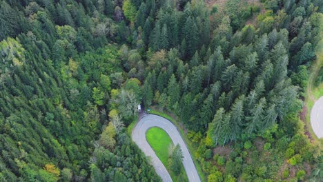 Aerial-view-of-countryside-road-in-the-green-forest-and-mountain-Eisenkappel-Vellach,-Austria