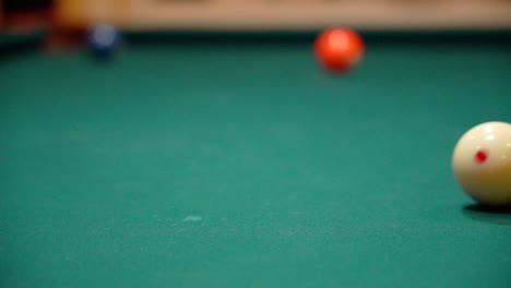 Slow-Motion-Billiards-White-Cue-Ball-Rolls-Across-Pool-Table-with-Green-Felt-Close-Up-from-a-Low-Angle