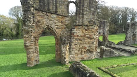 Basingwerk-abbey-landmark-medieval-abandoned-Welsh-ruins-Aerial-view-close-orbiting-right-pull-back