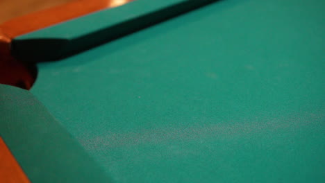 Slow-Motion-Billiards-solid-black-8-ball-shot-in-corner-pocket-on-pool-table-with-green-felt-and-brown-pockets-using-the-cue-ball-and-back-spin-or-draw-Close-Up-with-Red-Spinning-Dots